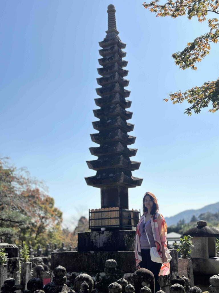 A person standing in front of a pagoda at Adashino Nenbutsuji temple in Japan