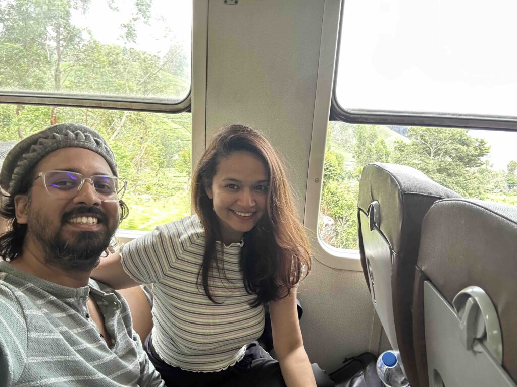 A man and a woman sitting inside the Ella Odyssey train in Sri Lanka