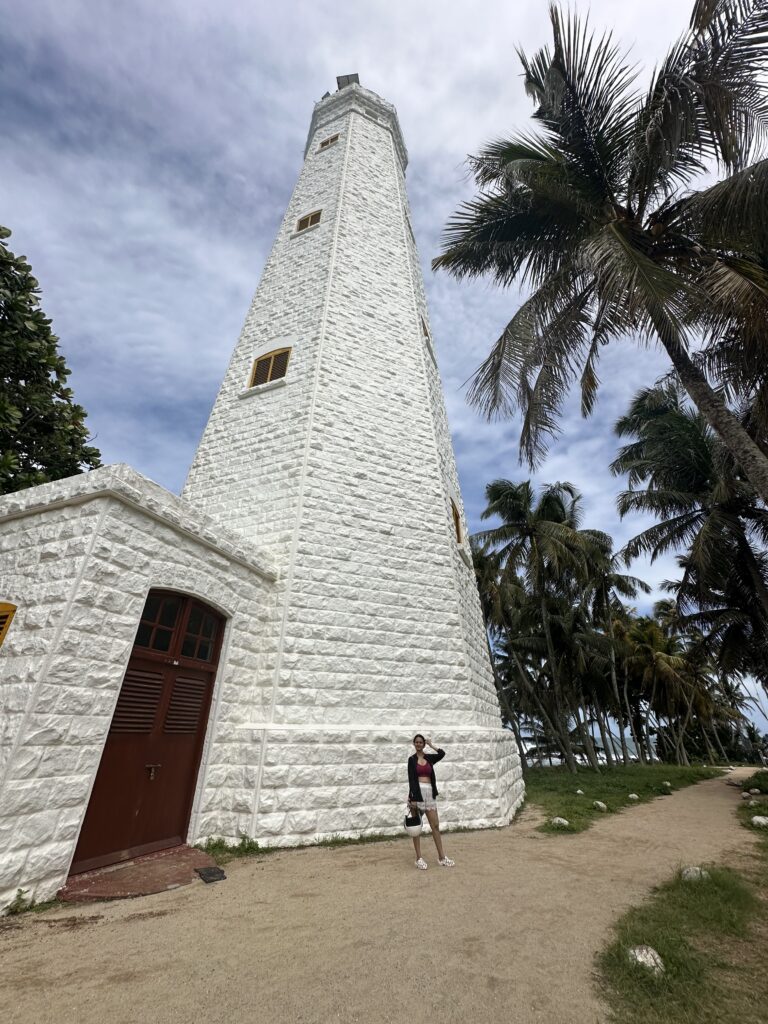 A person standing in front of Dondra Lighthouse in Sri Lanka, one of the best places to visit in South Sri Lanka in monsoons
